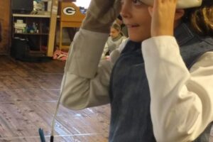 Foil fencing putting on mask, Anna